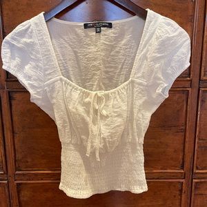One Love cap sleeve blouse with a cinched neckline and fitted crop waist.